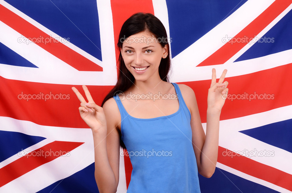 Portrait of a beautiful British girl smiling and signing victory.