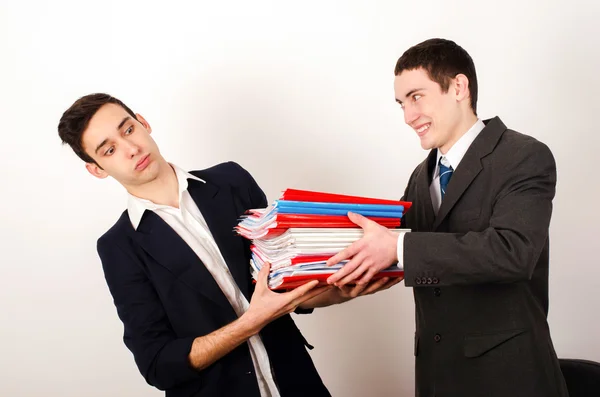Trabajador desesperado recibiendo un montón de papeleo de su feliz jefe . —  Fotos de Stock