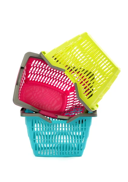 Warenkorb aus blauem, gelbem und rosa Kunststoff isoliert auf weiß. — Stockfoto