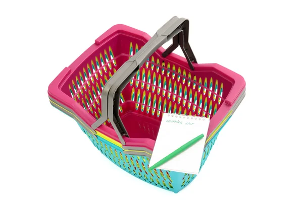 Colorful plastic shopping basket with blank shopping list. — Stock Photo, Image