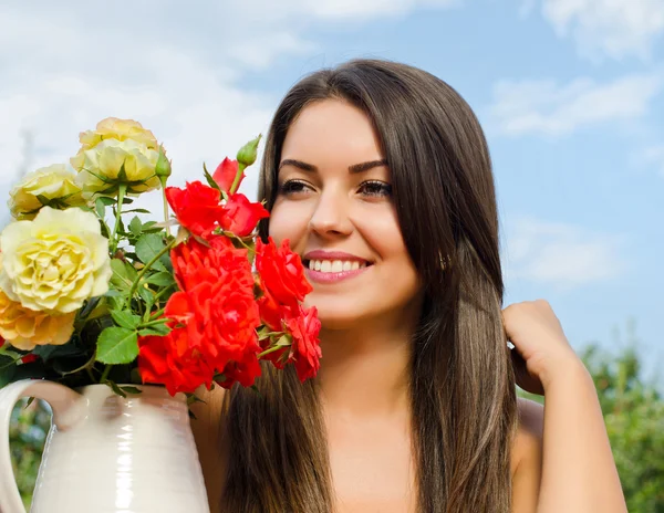 Bella donna in giardino con fiori . — Foto Stock