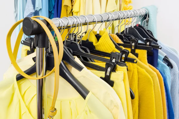 Fechar em cor roupas coordenadas em cabides em uma loja . — Fotografia de Stock