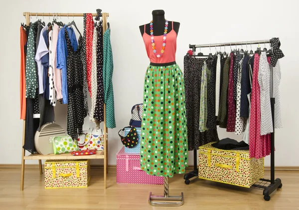 Klä garderob med prickar kläder ordnade på galgar och en outfit på en skyltdocka. — Stockfoto