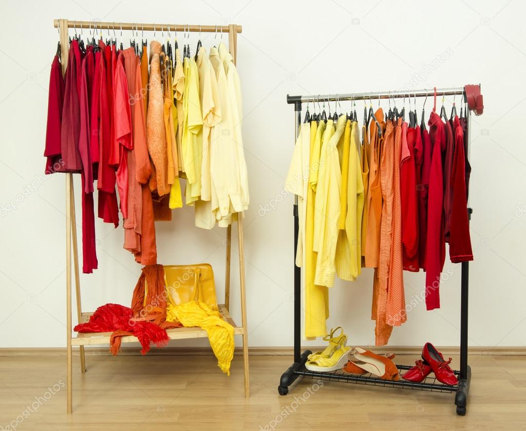 Shades of yellow, orange and red clothes hanging on a rack nicely arranged.