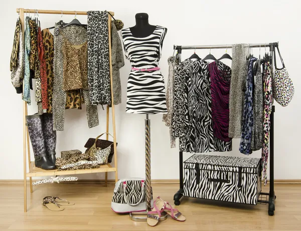 Dressing closet with animal print clothes arranged on hangers and a zebra print outfit on a mannequin. — Stock Photo, Image