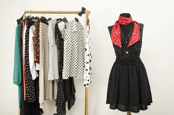 Dressing closet with polka dots clothes arranged on hangers and an outfit on a mannequin. — Stock Photo, Image