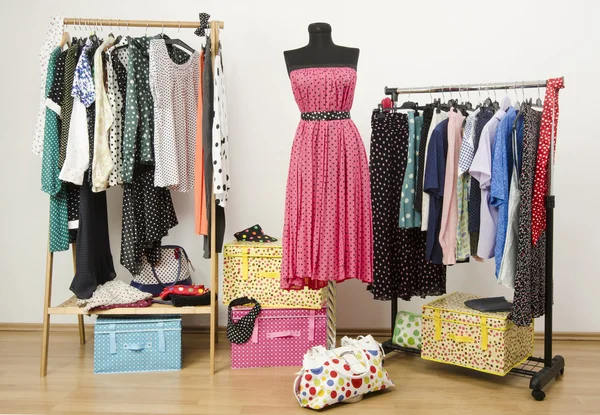 Dressing closet with polka dots clothes arranged on hangers and a dress on a mannequin. — Stock Photo, Image