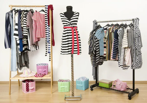 Dressing closet with striped clothes arranged on hangers. — Stock Photo, Image