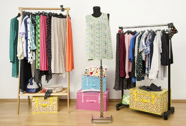 Dressing closet with polka dots clothes arranged on hangers and an outfit on a mannequin. — Stock Photo, Image