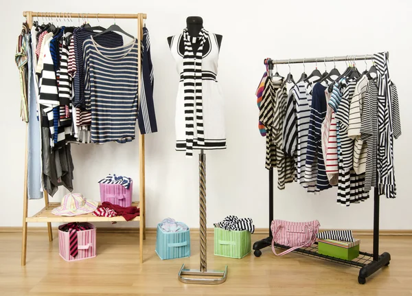 Dressing closet with striped clothes arranged on hangers. — Stock Photo, Image