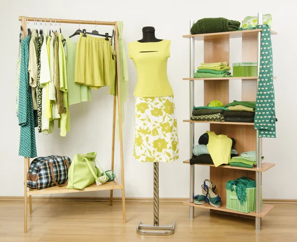 Vestidor armario con ropa verde arreglado en perchas y estante, traje verde neón en un maniquí . — Foto de Stock