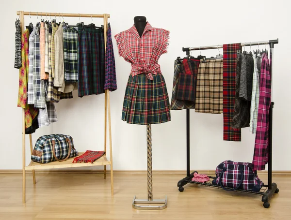 Dressing kast met geruite kleren gerangschikt op ruimte voor hangers en een outfit op een mannequin. — Stockfoto