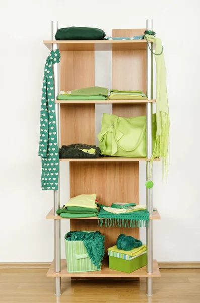 Green clothes nicely arranged on a shelf. — Stock Photo, Image