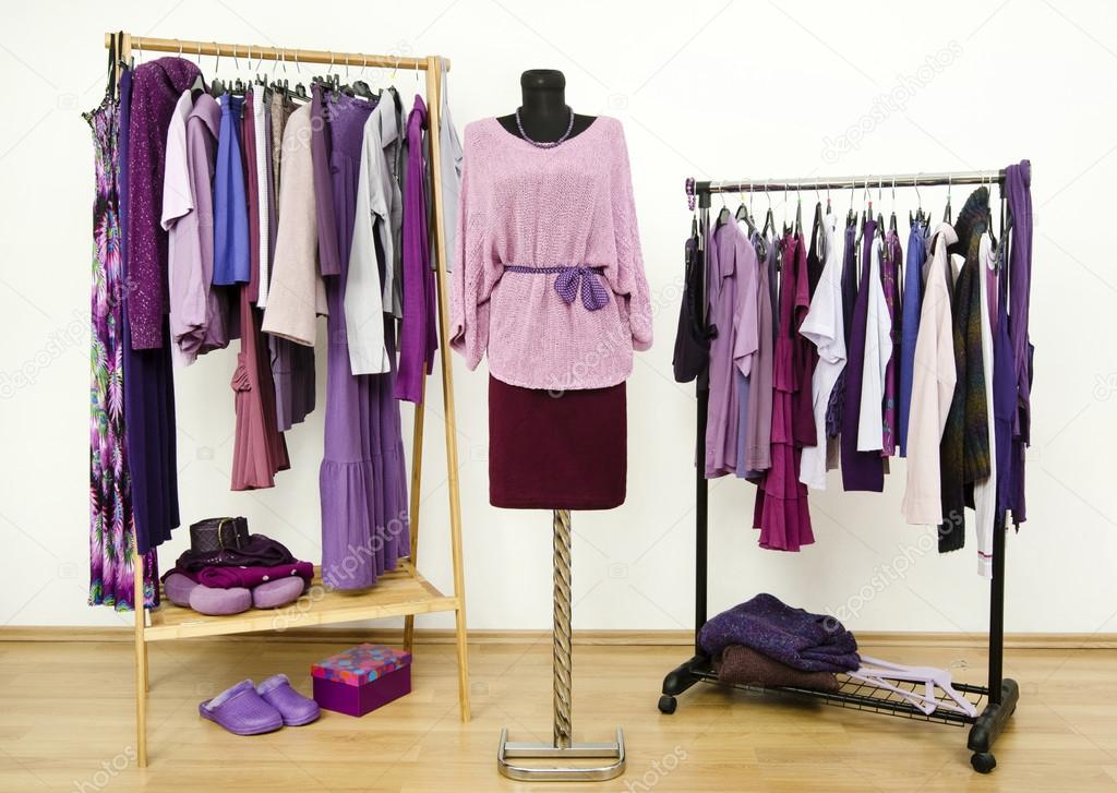 Wardrobe with purple clothes arranged on hangers and an outfit on a mannequin.