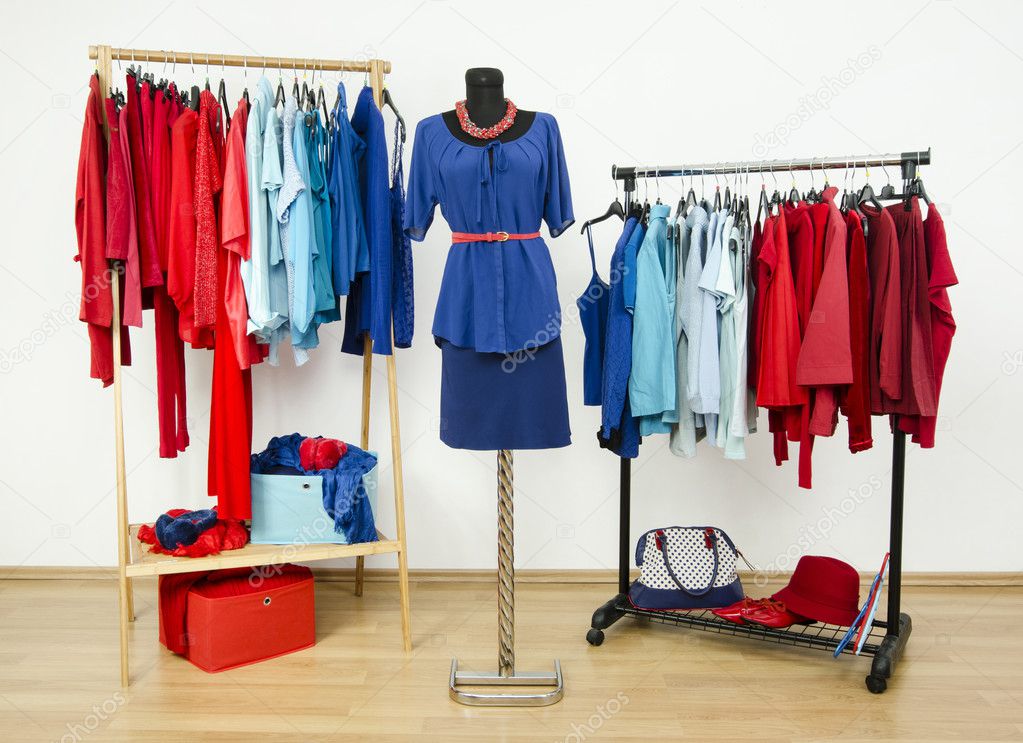 Wardrobe with red and blue clothes arranged on hangers and an outfit on a mannequin.