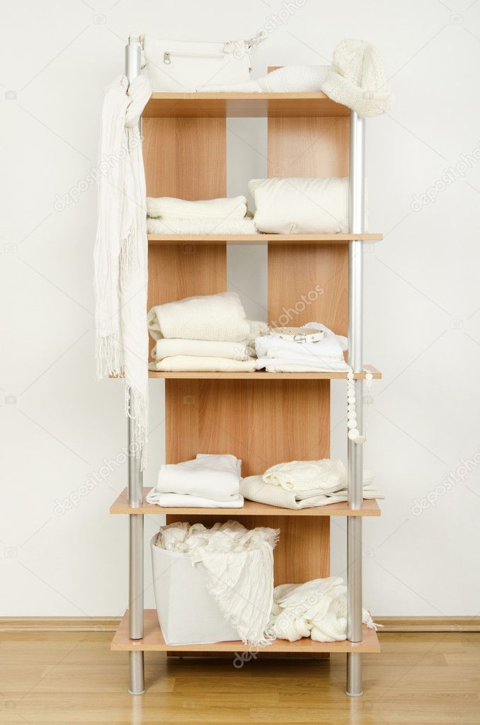 White clothes nicely arranged on a shelf.