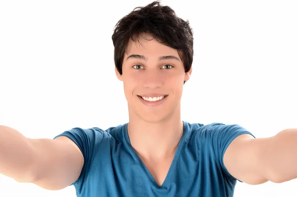 Um homem a sorrir com as mãos estendidas. Jovem feliz tirando uma foto selfie . — Fotografia de Stock