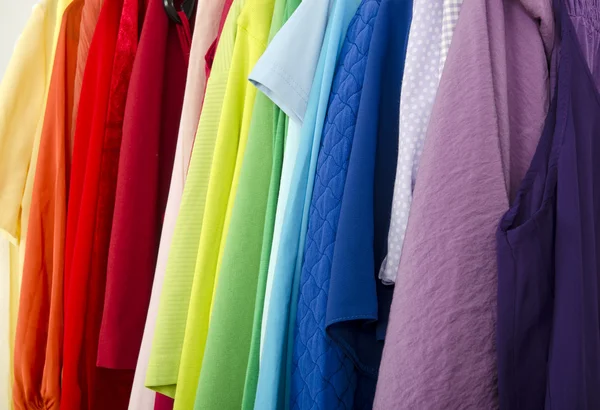 Close up on color coordinated clothes on hangers in a store. — Stock Photo, Image