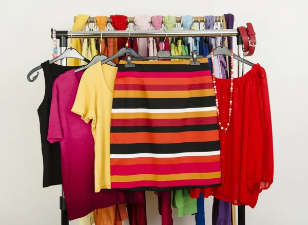 Roupas de verão bonito exibido em um rack. Saia listrada com blusas combinando . — Fotografia de Stock