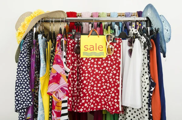 Cute summer outfits displayed on hangers with a big sale sign. — Stock Photo, Image