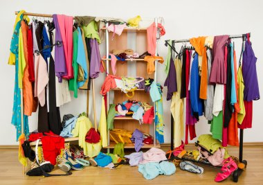 Untidy cluttered woman wardrobe with colorful clothes and accessories. clipart