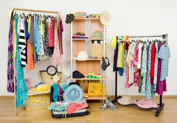 Packing the suitcase for summer vacation. Wardrobe with summer clothes nicely arranged and a full luggage. — Stock Photo, Image