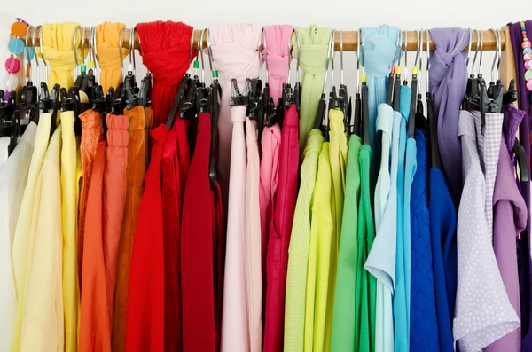 Close up on color coordinated clothes on hangers in a store. — Stock Photo, Image