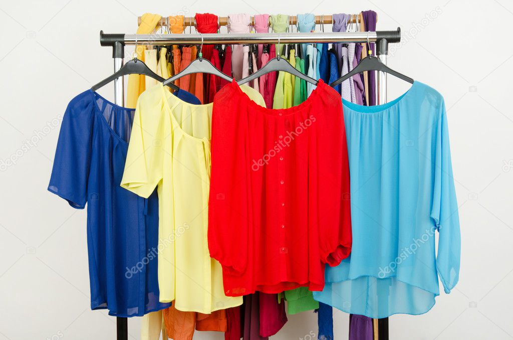 Cute red, yellow, blue blouses displayed on a rack.