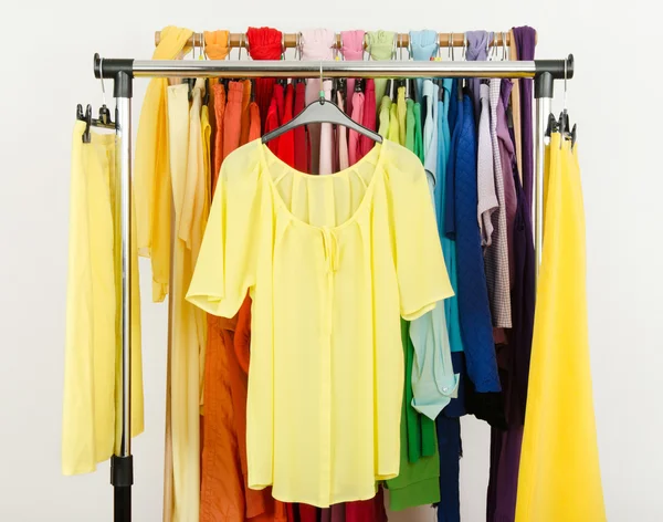 Niedliche gelbe Bluse und Röcke auf einem Regal. — Stockfoto