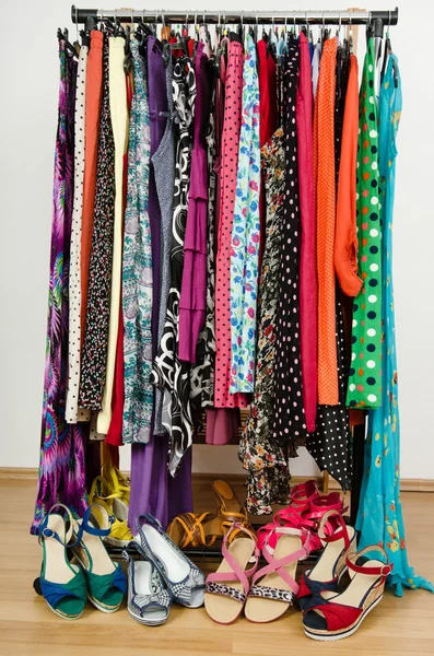 Armário de vestir com roupas coloridas e sapatos bem dispostos em um rack . — Fotografia de Stock