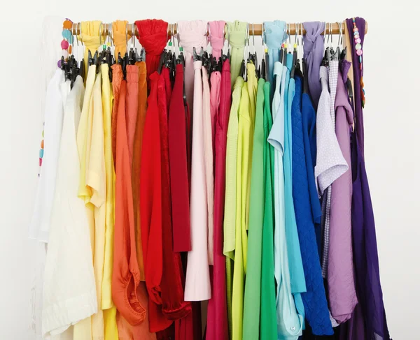 Close up on color coordinated clothes on hangers in a store. — Stock Photo, Image