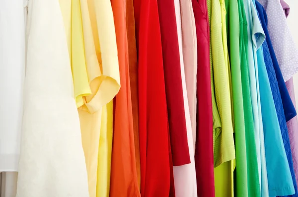 Close up on color coordinated clothes on hangers in a store. — Stock Photo, Image