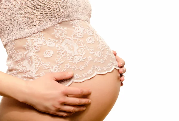 Close up on pregnant belly in a pink lace top. — Stock Photo, Image