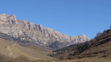Guloykhi Vadisi 'ndeki dağ sıraları ve kayalardan oluşan bir panorama. Kuzey Kafkasya, Ingushetia Cumhuriyeti' ndeki yüksek dağlık Dzheyrakh-Assinsky Doğal Müze-Rezervi 'de mavi gökyüzü.