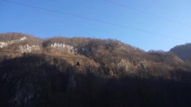Dzheyrakh vadisinin panoraması mavi gökyüzü ve dağ sıraları ve hareket halindeki arabası Ingushetia, Kuzey Kafkasya 'da uçan bir kartal.