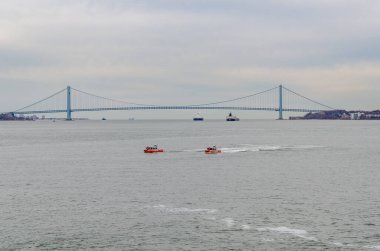 Verrazano-Narrows Köprüsü 'nün önündeki Hudson Nehri' nde iki Birleşik Devletler Sahil Güvenlik gemisi ve iki sanayi gemisi.