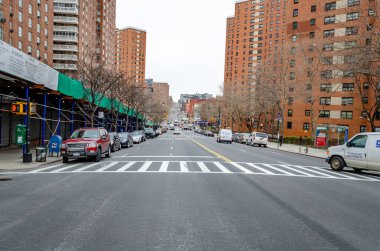 Eski apartman daireleri olan yerleşim alanı Harlem, New York 'ta yaya geçidi ve trafik olan şehir caddesi.
