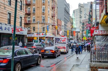 Yağmurlu bir kış gününde, Çin Kasabası New York 'ta kaldırımda şemsiyeyle yürüyen insanlarla trafik sıkışıklığı