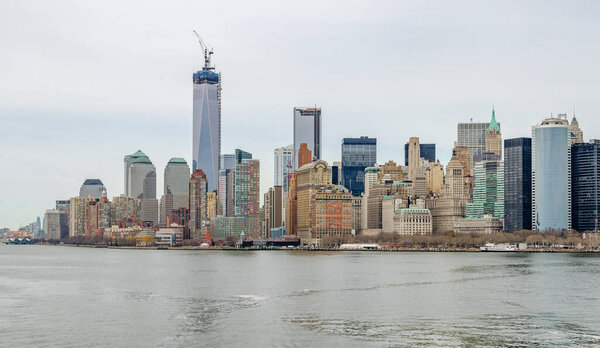 Manhattan Skyline with One World Trade Center construction site and Hudson river in forefront