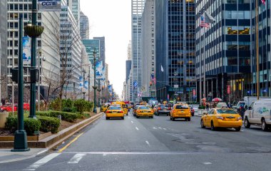 Akşamları Manhattan 'da geniş bir sokakta sarı taksiler, caddelerde çok trafik, sağda ve solda gökdelen, New York City, yatay
