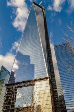 Penceresinde bulutların yansıması olan bir Dünya Ticaret Merkezi inşaat alanı, bulutlu gündüzleri üstte vinç, New York City, alçak açılı, dikey