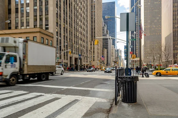 Manhattan New York City, Radio City Music Hall 'un yanındaki caddede çok trafik, yaya geçidi ve çöp tenekesi var.