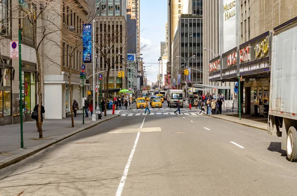 トラフィック 黄色のタクシーと車でラジオシティミュージックホールの横にあるニューヨーク市の通り 昼間の2つの横断歩道の後ろの地平線 水平線 — ストック写真
