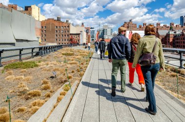 İnsanlar yürüyorlar, güneşli kış gününün tadını çıkarıyorlar High Line Park, NYC, dikiz manzarası