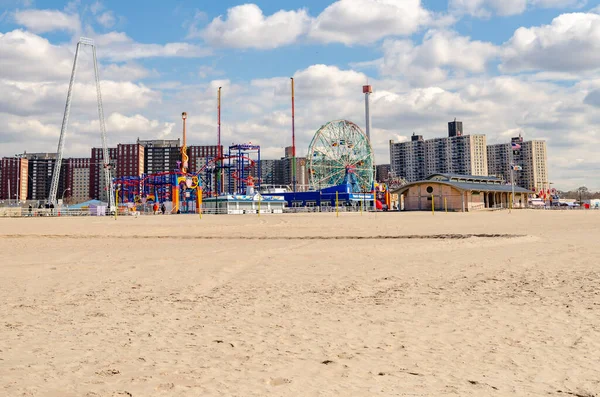 Güneşli kış gününde önünde plaj olan Coney Island Luna Parkı, New York