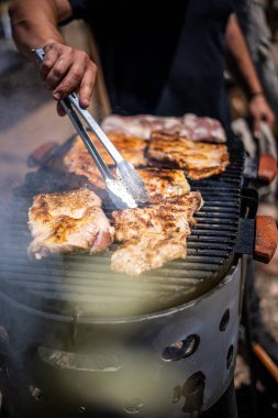 Geleneksel Arjantin asado 'su açık havada mangal kömürü ve ateşle pişiriliyor.