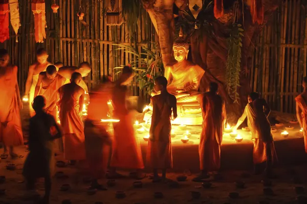 Buddhist monk fire candles to the Buddha — Stock Photo, Image
