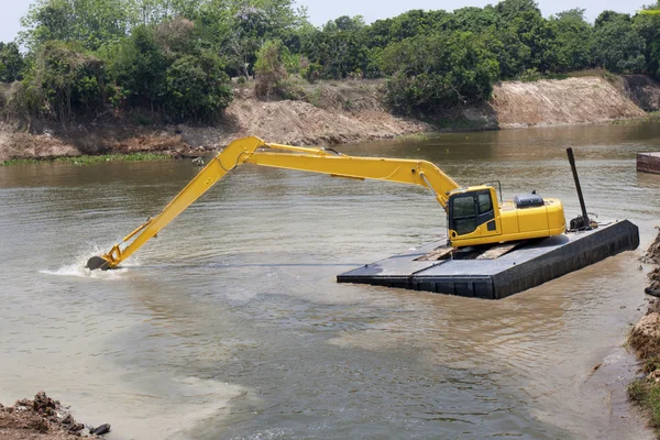 Máquina escavadora funciona no rio — Fotografia de Stock
