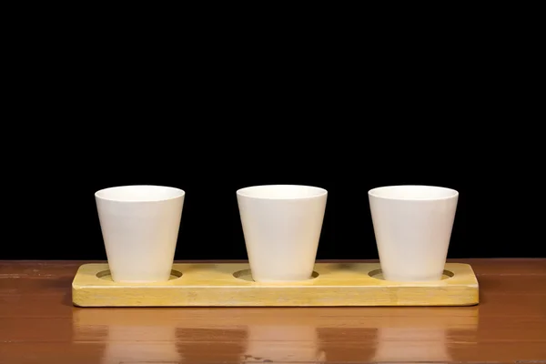 Three white cups on wooden isolated — Stock Photo, Image