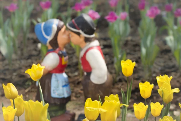 两个接吻娃娃在郁金香花园. — 图库照片